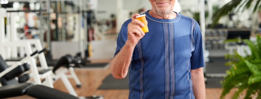senior man with pills at gym