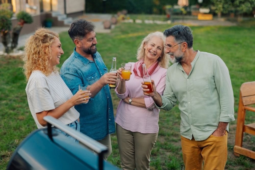 Friends and family toasting drinks at a backyard barbecue