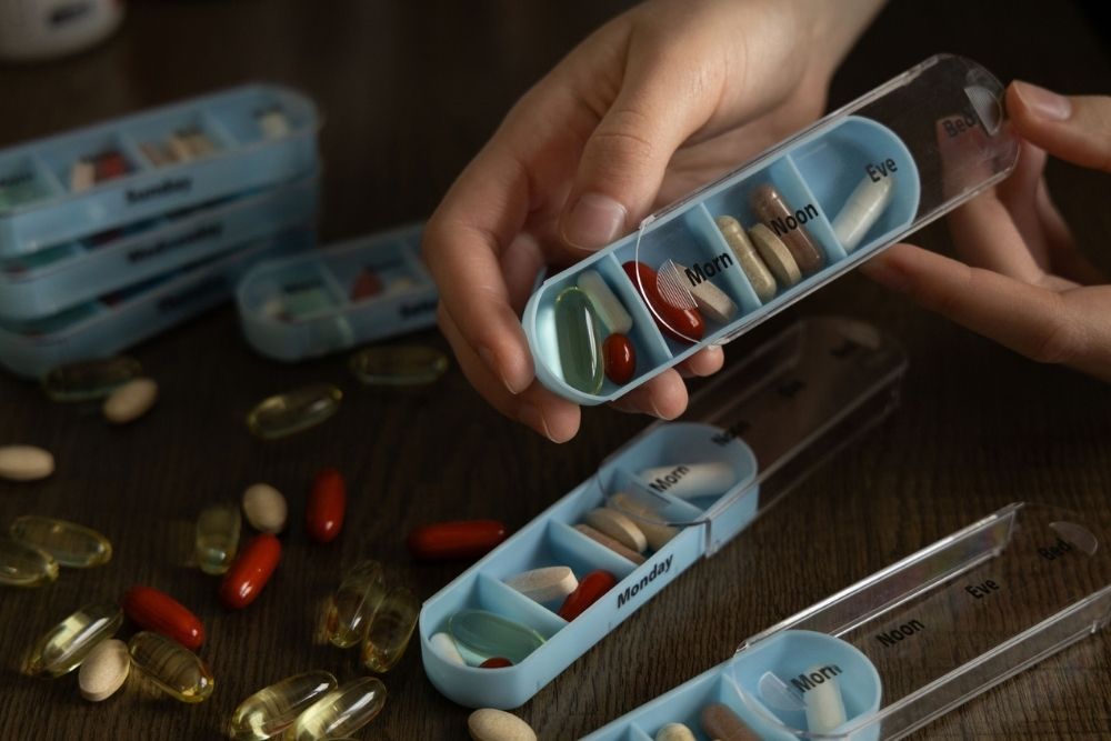 Filling a weekly pill organizer with vitamins at home Filling a weekly pill organizer with vitamins at home