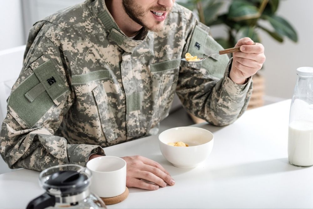 Service member in uniform eating breakfast